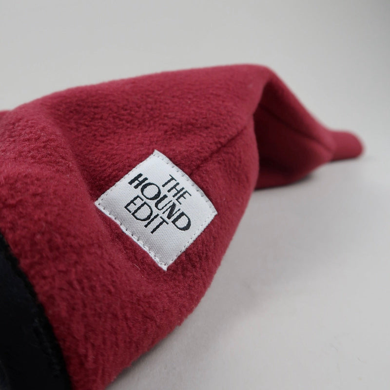 Burgundy red Italian Greyhound fleece jumper close-up with a white label reading 'The Hound Edit' on a light grey background
